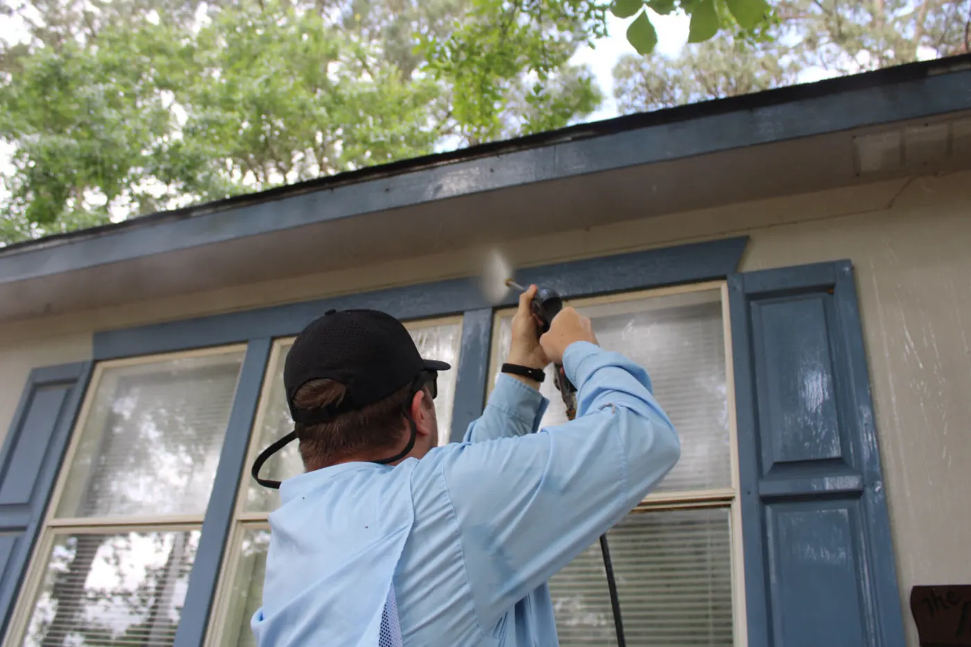 Kollin Goodman washing a home's windows and trim
